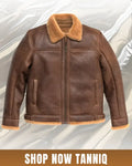 Brown leather jacket with fur collar on a light gray background