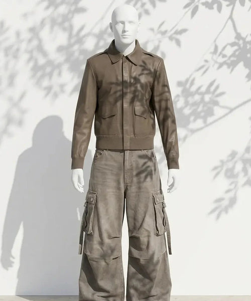 Mannequin wearing a brown jacket and cargo pants against a white background with leaf shadows.